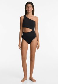 Crni jednodijelni kupaći kostim s jednim naramenicom, izrezom u struku i rebrastom teksturom.