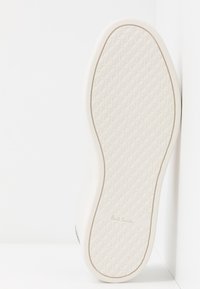 Semelle blanche en caoutchouc d'une basket avec motif de grip texturé et logo "Paul Smith" embossé près du talon.