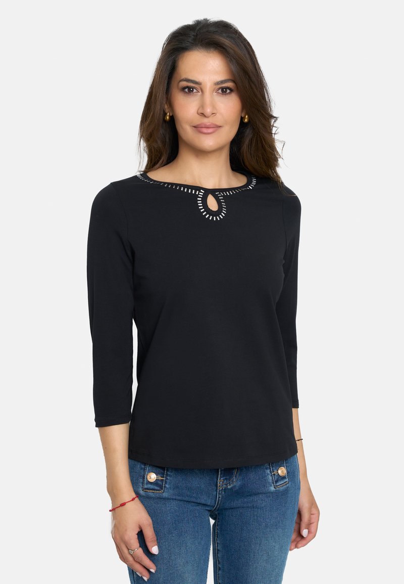 Top negro de manga larga con escote de ojo de cerradura decorado con costuras blancas. Tejido suave con una forma ligeramente ajustada.