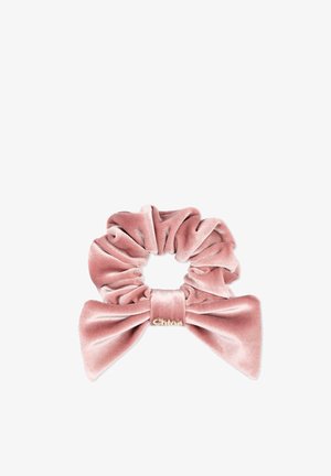 Coletero de terciopelo rosa con un gran lazo y un pequeño detalle de logo dorado sobre un fondo blanco liso.