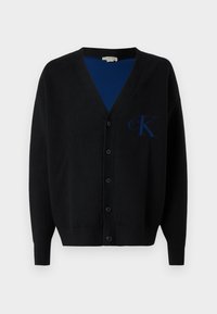 Cardigã preto feito de tecido suave, com decote em V, mangas compridas, seis botões e um logo azul "cK" no lado esquerdo.