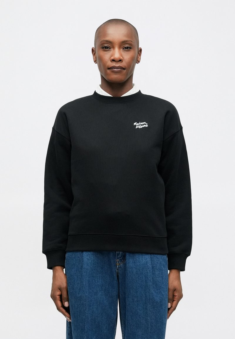 Sudadera negra con cuello redondo acanalado, que presenta un logotipo blanco bordado en el pecho. Material suave, corte relajado y mangas largas.