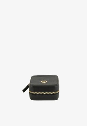 Boîte à bijoux carrée noire avec fermeture éclair dorée et accent en forme de cœur doré sur le dessus, surface texturée et languette de fermeture éclair sur le côté.