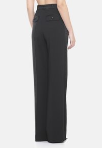 Pantalones anchos negros con una textura suave, cintura alta y dos bolsillos traseros con cierres de botón.