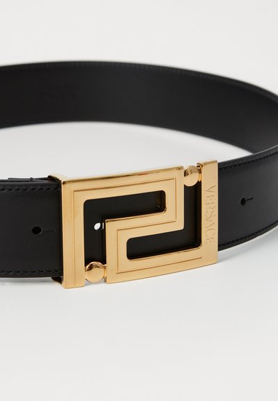Cinturón de cuero negro con hebilla geométrica dorada que presenta el logo de Versace, textura suave y múltiples agujeros de ajuste para un mejor calce.