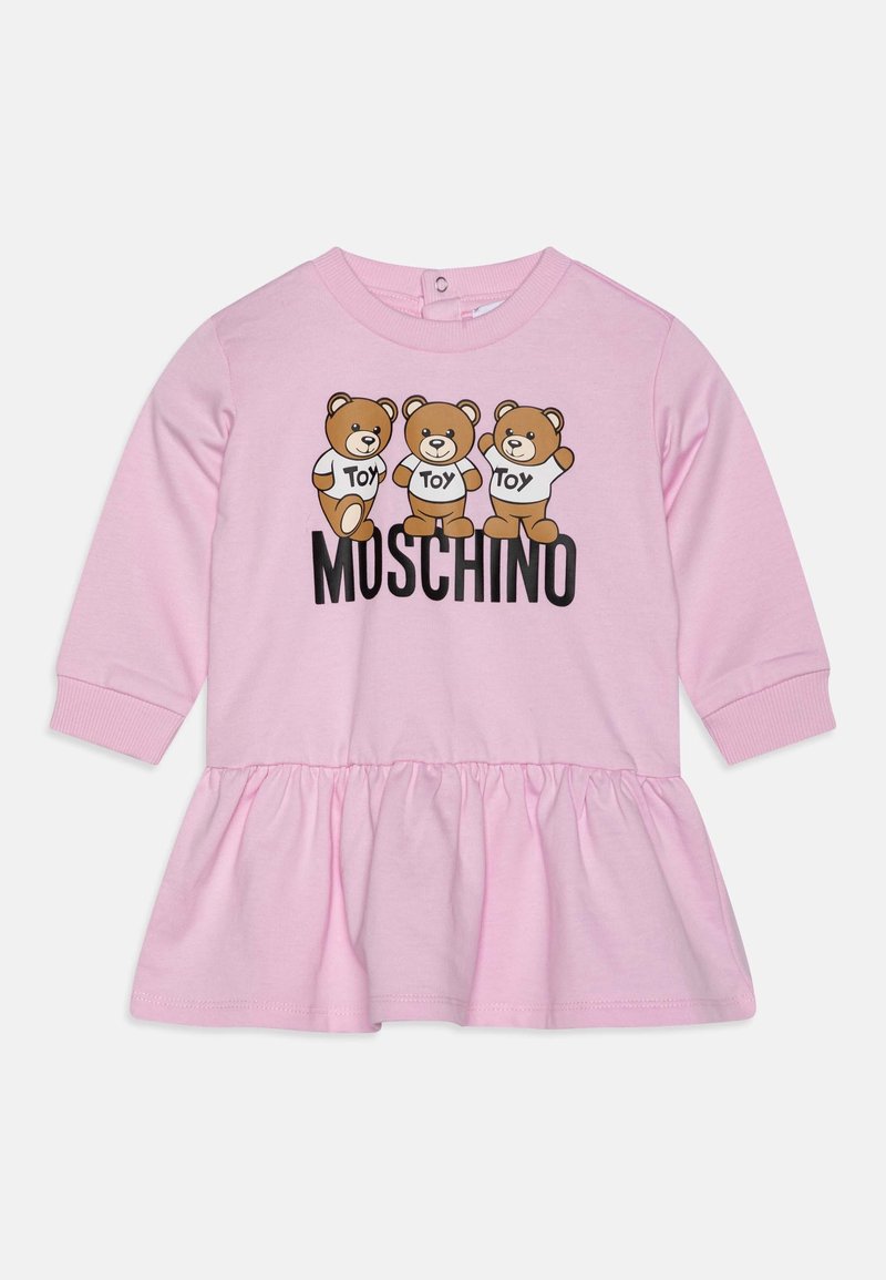 Robe rose à manches longues pour tout-petit, avec trois ours en peluche portant des t-shirts "Toy" et le mot "Moschino" imprimé en dessous.