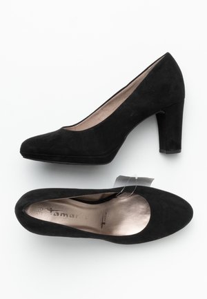 Chaussures à talons hauts en suède noir avec un bout arrondi, présentant une finition texturée et un intérieur brillant. Élévation grâce à un talon épais.