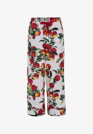 Białe spodnie w czerwone i żółte jabłka oraz zielone liście, z czerwoną sznurówką w pasie i podwiniętymi nogawkami.