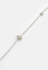 Zilveren armband met een verlengde ketting, een ronde sluiting en kraalaccenten, met een gladde, glanzende textuur en een eenvoudig ontwerp.