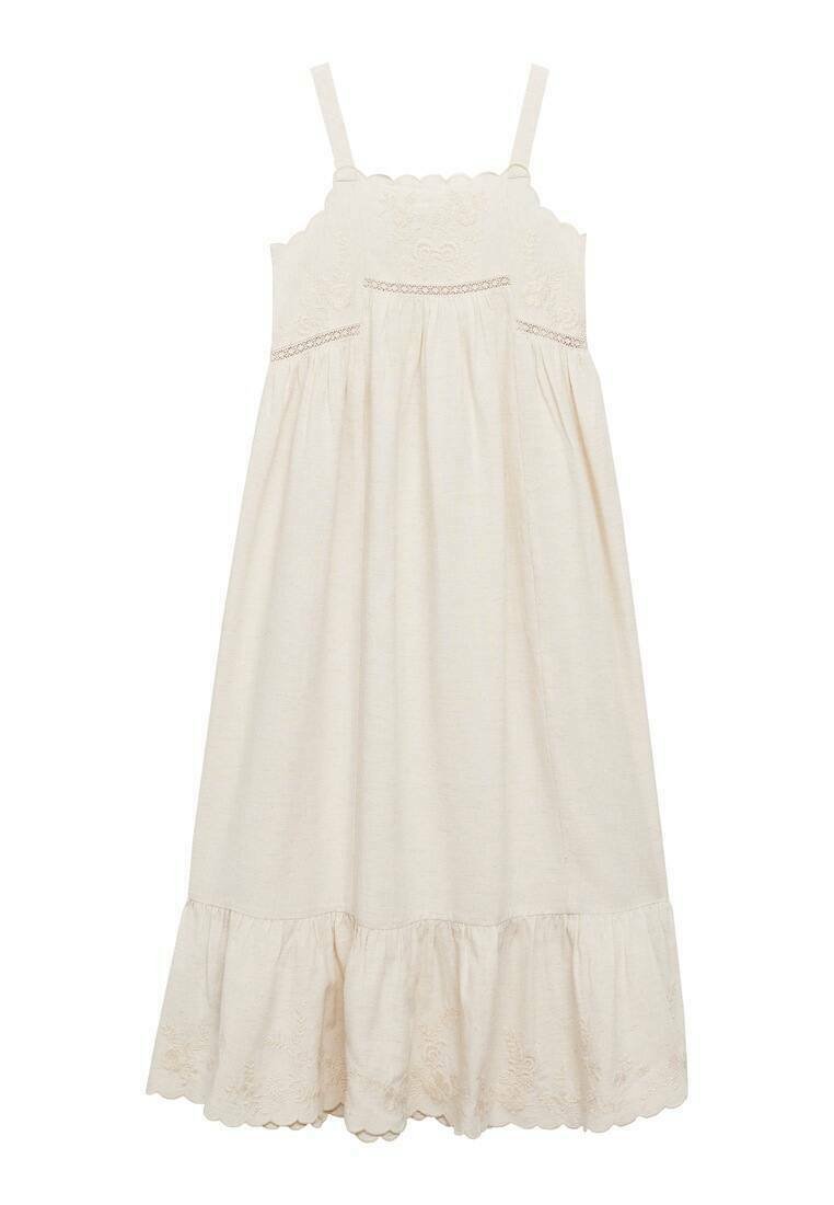 Abito beige chiaro con spalline sottili, corpetto ricamato a scallop, vita arricciata e orlo a strati con volant e motivi floreali.