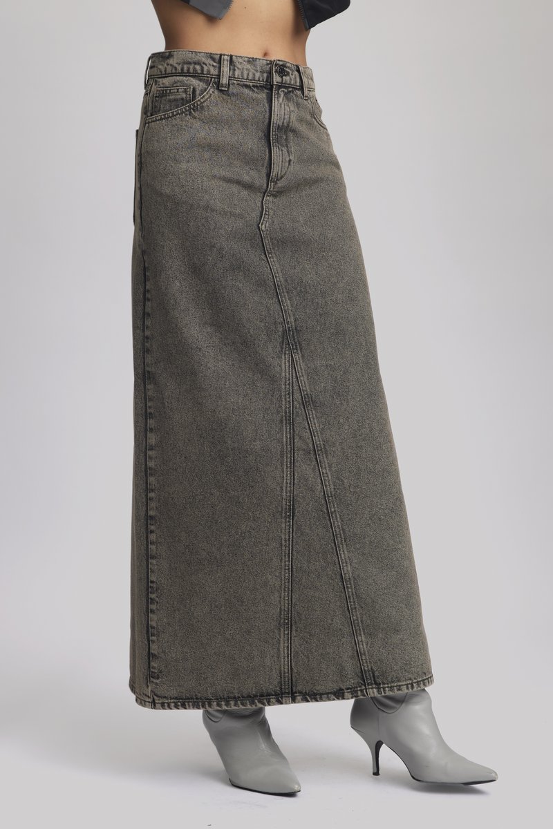 Szürke denim maxi szoknya egyenes szabással, látható varrással, magas derekú, szürke hegyes orrú cipővel párosítva.