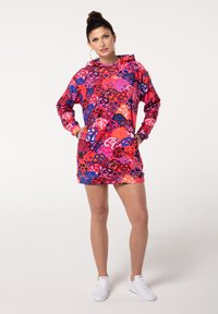 Farbenfrohes, gemustertes Kapuzenkleid in Pink-, Lila- und Blautönen. Verfügt über lange Ärmel, eine Kapuze und vordere Taschen. Aus weichem Stoff gefertigt.