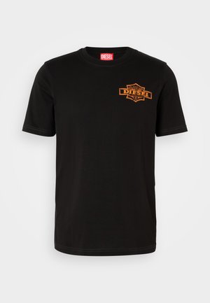 Crna pamučna majica s kratkim rukavima, okruglim izrezom i narančastim vezom Diesel logotipa na prsima. Bijeli šavovi akcentiraju.