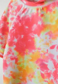 T-shirt de surf tie-dye dans des teintes de rose, orange et jaune. Doté d'un col rond et d'un tissu doux et extensible avec des manches courtes.