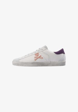 Zapatillas blancas con puntera gris, talón morado y bordado de calaveras y huesos cruzados en rosa. Suela texturizada con un diseño moteado.