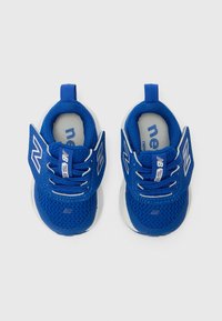 Baskets en mesh bleu avec semelles blanches, présentant un dessus texturé, des lacets et des accents de logo sur les côtés. Design à enfiler incluant un onglet arrière pour un enfilage facile.