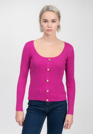 Taillierter, gerippter Langarmpullover in einem leuchtenden Pink mit einem runden Halsausschnitt und fünf quadratischen goldenen Knöpfen auf der Vorderseite.