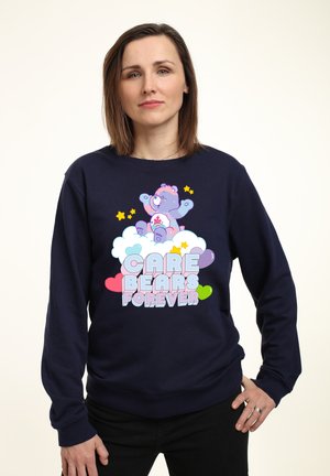Námořnicky modrá mikina s hravým motivem Medvídků z Lásky, duhových mráčků, hvězd a nápisem "CARE BEARS FOREVER" v pastelových barvách.