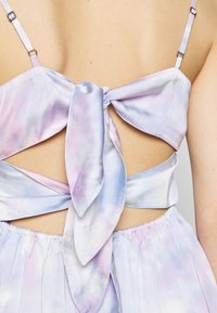 Takapuolet näkymä kevyestä, pastellinsävyisestä sitruunamehun muotomaalauksesta, jossa on satiinipinta. Mekossa on suuri solmittu nauhadetali ja ohuet säädettävät hihnat.