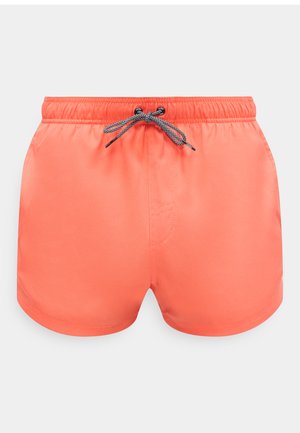 Bañadores de color coral con cintura elástica y nudo de cordón blanco y negro en el centro delantero.