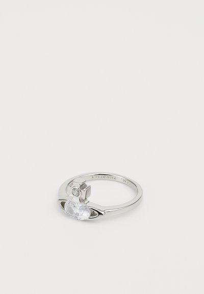 Anello d'argento con una pietra chiara ovale, accentuato da una pietra rotonda più piccola e da elementi di design unici che ricordano le orbite planetarie.