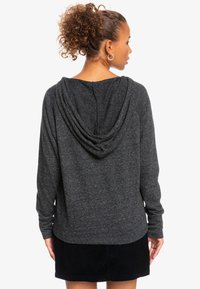 Mørkegrå hættetrøje lavet af blødt stof, med en draperet hætte og et enkelt rygdesign. Matcher en sort fløjlsnederdel.