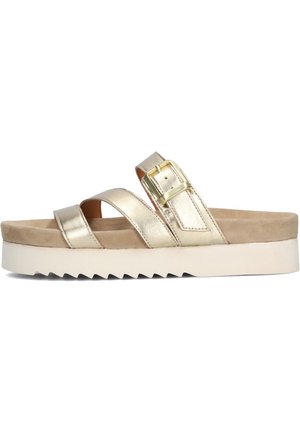 Sandales métalliques dorées avec des lanières entrecroisées et un détail de boucle, dotées d'une semelle intérieure rembourrée beige et d'une semelle blanche à motif en dents de scie.