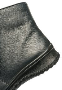 Black leather ankle boot with textured surface and rubber sole, shown from the side on a white background.