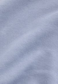 Tessuto azzurro chiaro, morbida texture, lavorazione a maglia, con una finitura liscia e una leggera lucentezza. Nessun motivo o accessorio visibile.