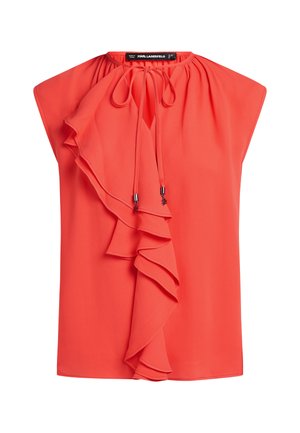 Red blouse with a round neckline, featuring a cascading ruffle detail on the left side and drawstring accents. Made from lightweight fabric.