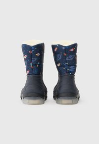 Botas de invierno navy con una parte superior acolchada que presenta un diseño espacial, forro de piel sintética blanca y una suela de goma negra con agarre texturizado.