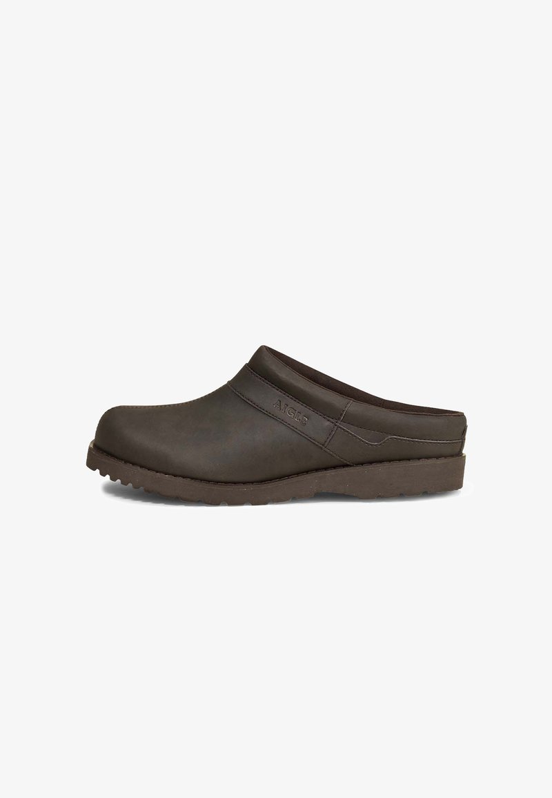 Dark brown clog with a smooth, matte finish. Features a rounded toe, low heel, and a textured rubber sole for grip. Minimal stitching details.