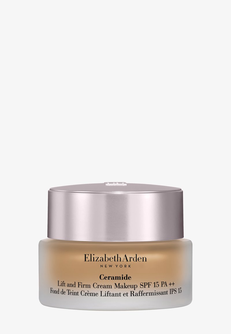 Tarro de crema maquillaje Elizabeth Arden Ceramide Lift and Firm con SPF 15 en vidrio esmerilado y tapa metálica sobre fondo blanco.