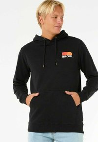 Zwarte hoodie met een frontale kangoeroe zak, een capuchon met trekkoord en een kleurrijk Rip Curl-logo op de borst. Gladde stoftextuur.