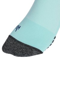 Calzino verde menta con punta grigia scura, tessuto testurizzato e un piccolo logo. Il design è alla caviglia con una finitura liscia.