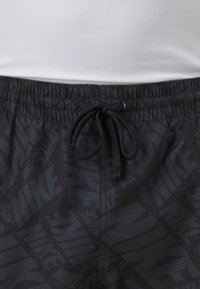 Șorturi atletice negre cu un model texturat care include logo-ul Nike. Talie elastică cu șnur ajustabil pentru o fixare confortabilă.