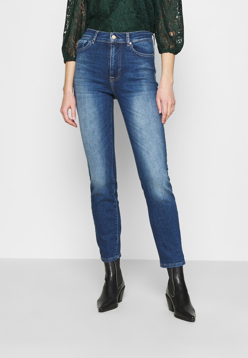 Jeans azul de cintura alta com um corte slim, desvanecendo de escuro para claro, design de cinco bolsos e fecho em botão de metal na cintura.