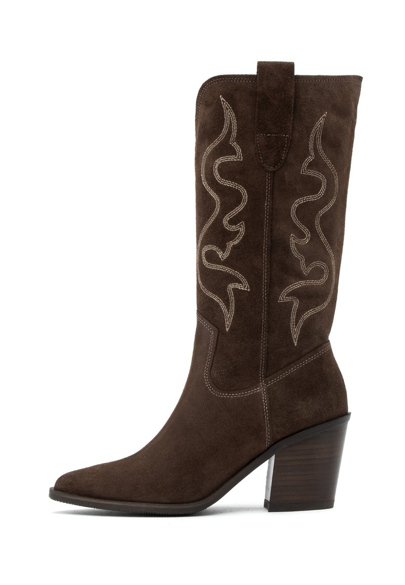 Bota western de ante marrón con punta afilada, costuras decorativas en crema en patrones de espiral y un tacón alto apilado.
