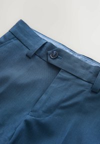 Marineblaue Hosen mit glatter Textur, flachem Bund, Knopfverschluss und Gürtelschlaufen. Das Innere hat ein kontrastierendes hellblaues Futter.