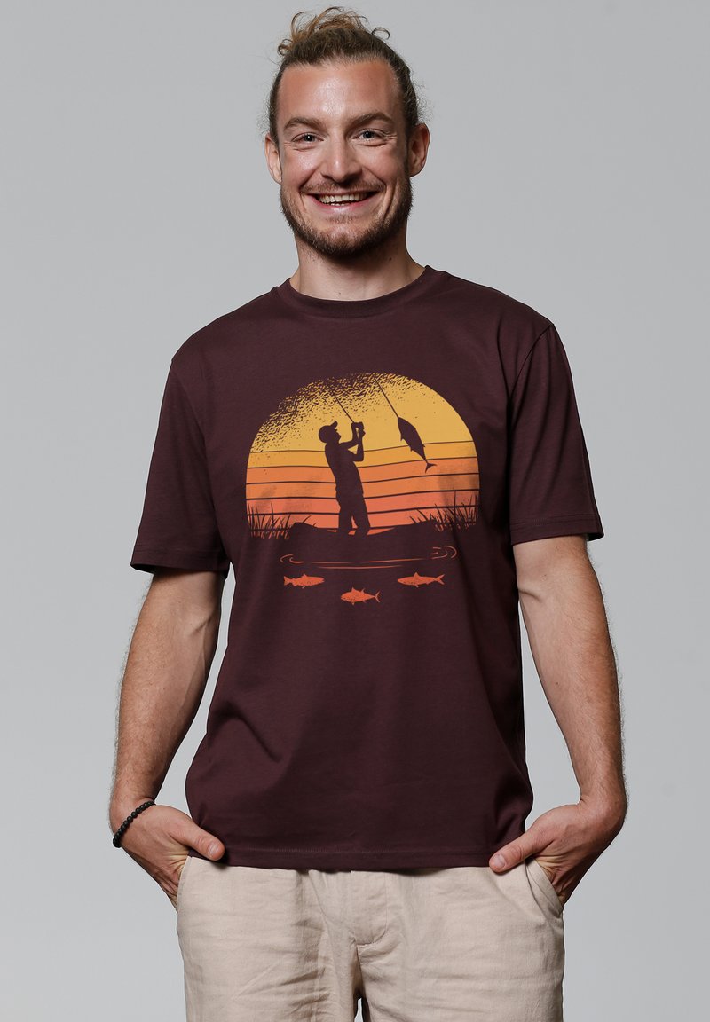 Bordeaux katoenen T-shirt met een grafisch ontwerp van een visscène met een zonsonderganggradiënt, silhouet van een visser en oranje visdetails. Korte mouwen, ronde hals.