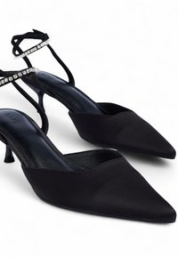 Melnas samta vireseņe ar īsu pirkstu, ar pievilcīgu satīna apdari un jostu, kas rotāta ar caurspīdīgiem rhinestones pie potītes.