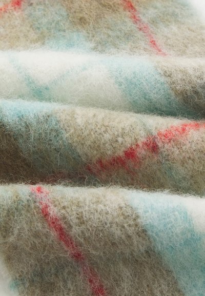 Tissu en laine dans des teintes de marron, crème et bleu clair, avec une texture douce et des rayures diagonales rouges. Plié avec une apparence duveteuse.