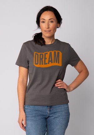 T-shirt en coton gris avec un grand graphique orange "DREAM" sur le devant. Manches courtes, col rond et coupe décontractée.