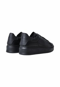 Sneaker in pelle nera con una texture liscia, punta rotonda e suola in gomma spessa. Presenta un logo in rilievo sul tallone.