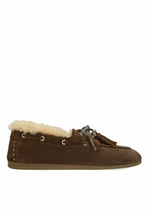 Bruine suède mocassin pantoffel met crèmekleurige bontvoering, decoratieve veters met kwastjes en platte rubberen zool.