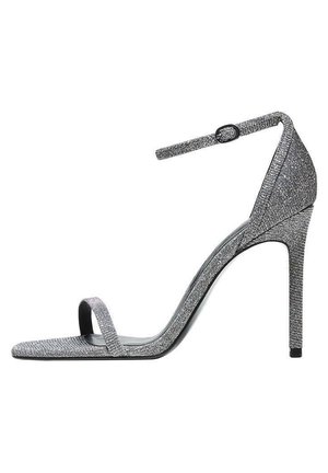 Sandale à talons hauts argentée avec une fine bride de cheville, design ouvert au niveau des orteils, et surface en tissu texturé. Caractéristiques d'un bout pointu et d'un talon aiguille.