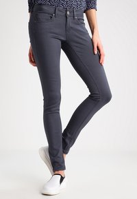 Jean skinny gris en coton extensible, avec cinq poches, fermeture à bouton à l'avant et une finition lisse.