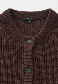 Donkerbruine gebreide cardigan met ronde hals, twee zwarte knopen en een zwart maatlabel met "OPUS 36" bij de kraag.