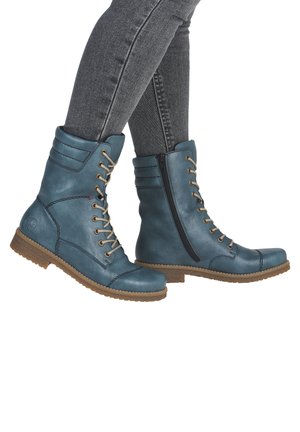 Blaue Leder Schnürstiefel verfügen über auffällige Nähte, eine leicht abgerundete Zehenpartie und einen seitlichen Reißverschluss, ausgestattet mit einer strukturierten, tanfarbenen Sohle.