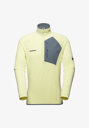 Fleece jaune clair à manches longues avec une demi-fermeture éclair, poche poitrine grise avec fermeture éclair, et logo Mammut sur la poitrine et la manche.